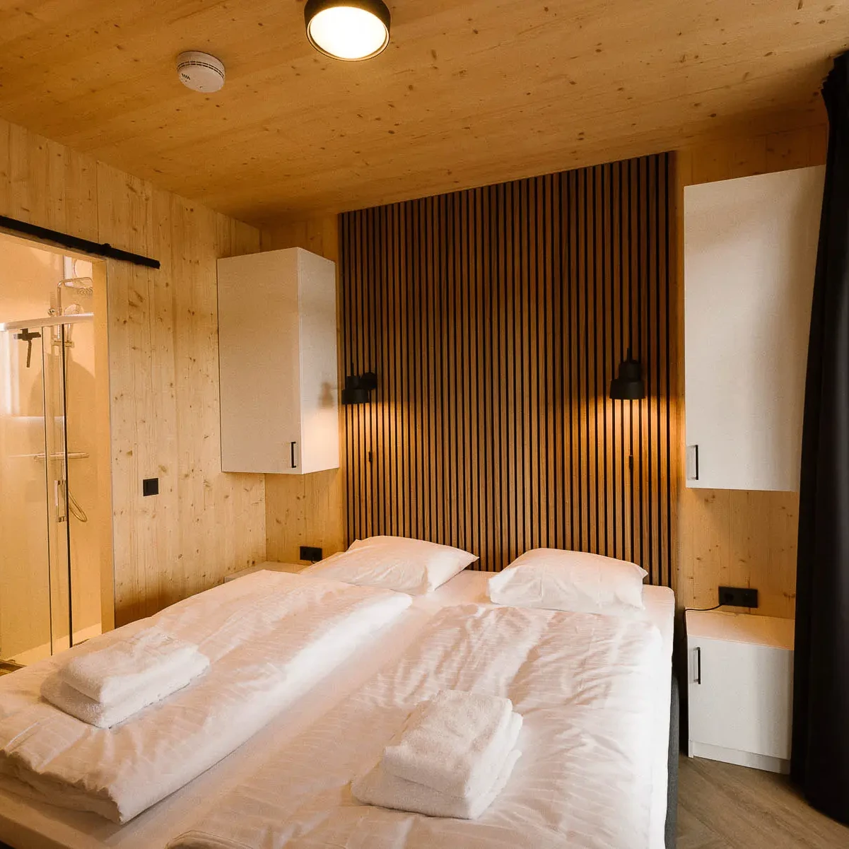 Luxe slaapkamer met houten afwerking en ensuite badkamer in Panorama Lodge Markelo