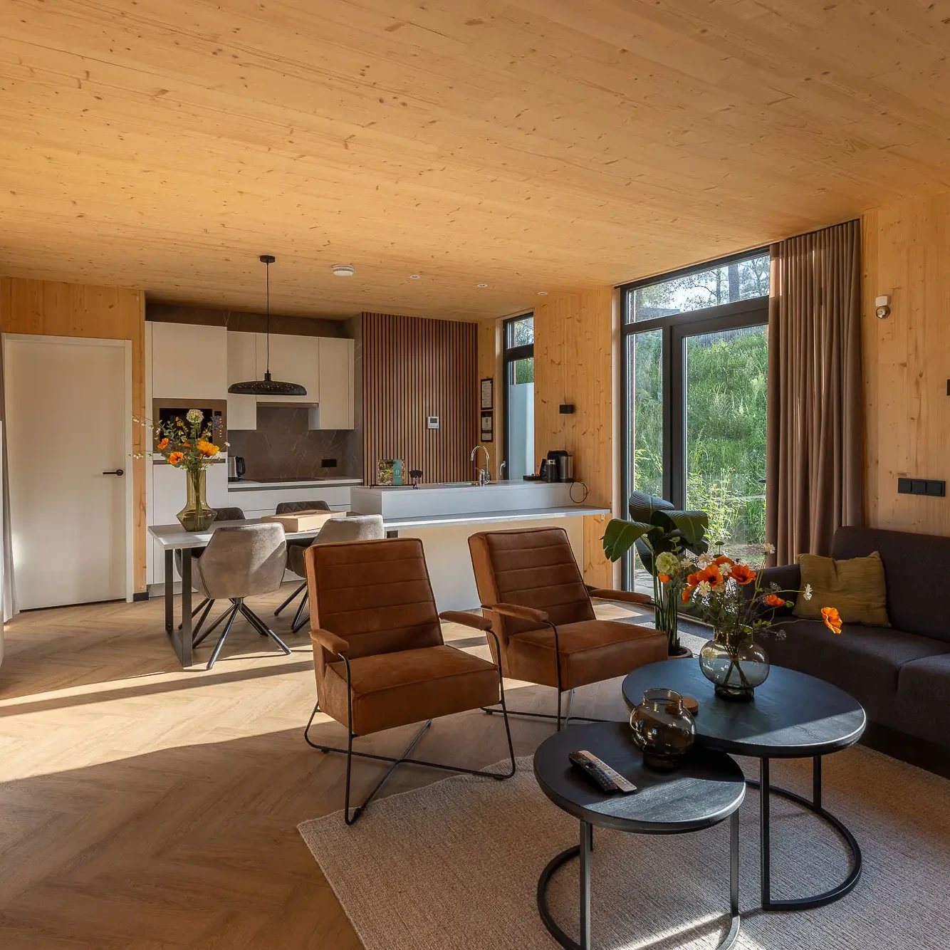 Luxe woonkamer met open keuken in houten Panorama lodge Zicht op Twente Markelo