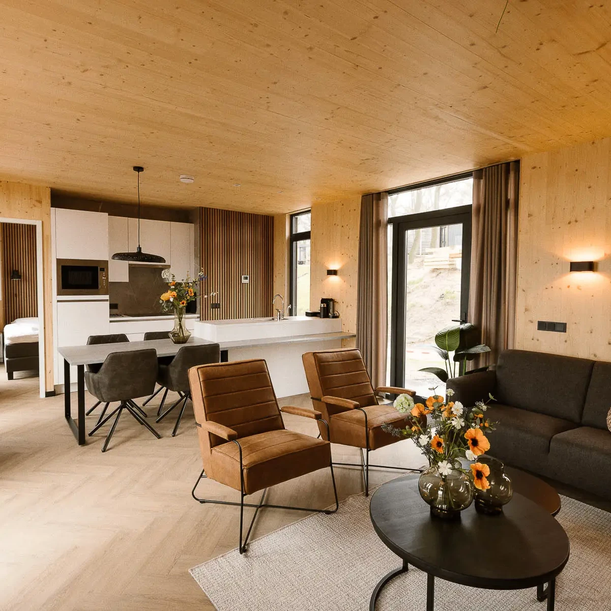Ruime woonkamer met open keuken in luxe Panorama lodge Zicht op Twente Markelo