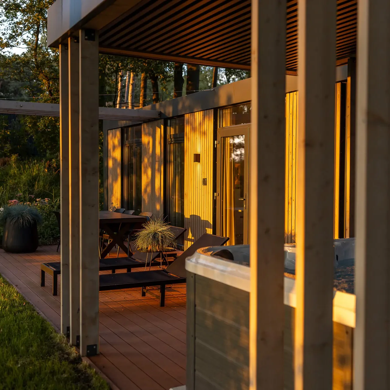 Luxe lodge met hottub en houten terras bij zonsondergang in Markelo