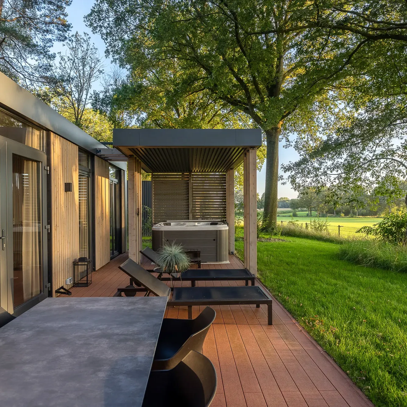 Luxe terras met jacuzzi en ligbedden bij Panorama Lodge Zicht op Twente Markelo