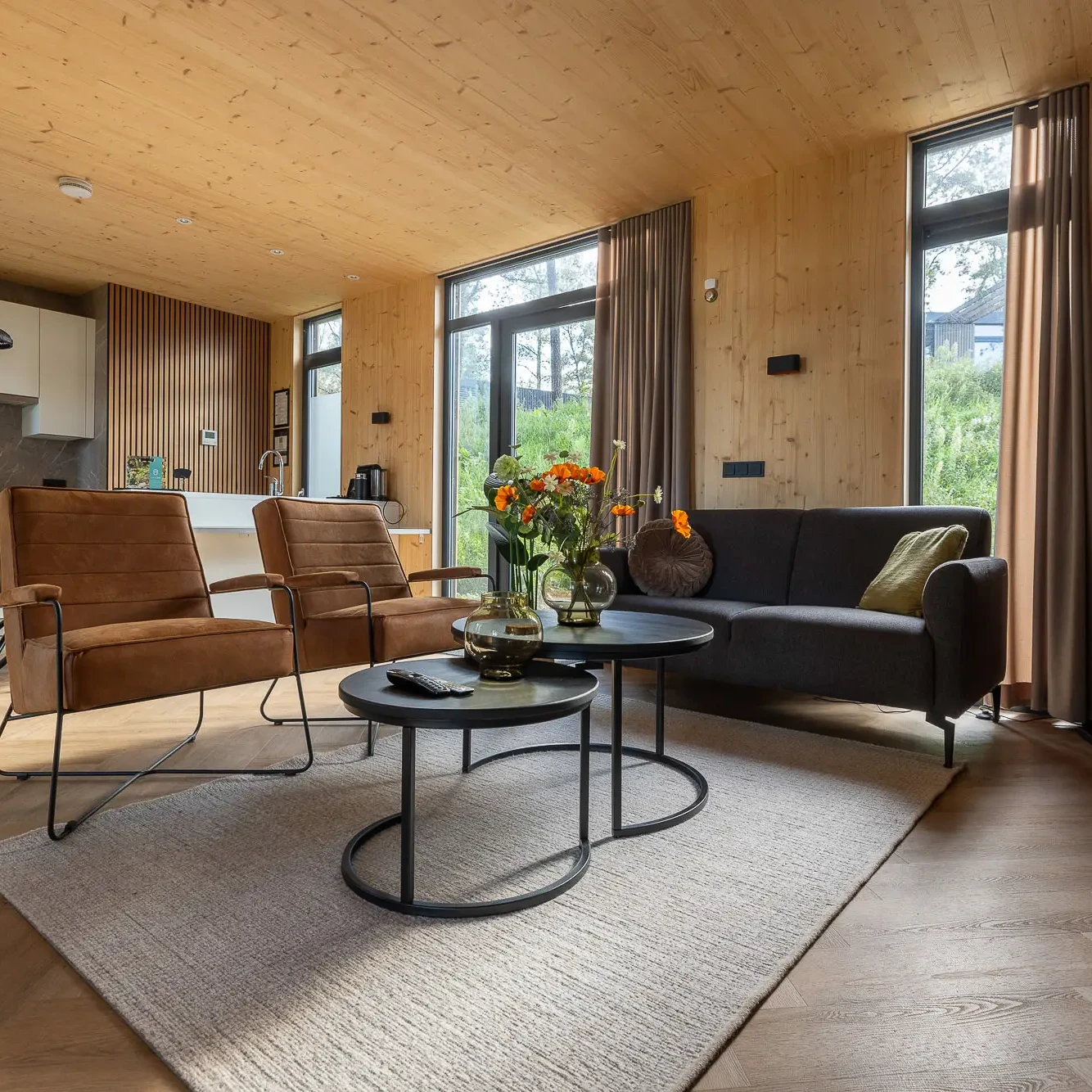 Luxe woonkamer met houten wanden en plafond in Panorama Lodge Markelo met moderne meubels